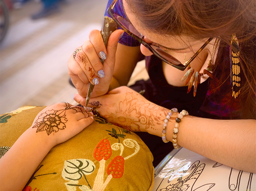 Madalina applying henna to a individuals hand. It feels calm and comfortable.